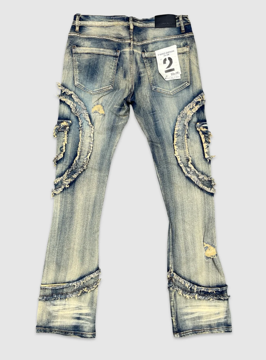 Back view of men's distressed denim jeans featuring faded wash, frayed curved patch details, ripped accents, and leather waistband tag.