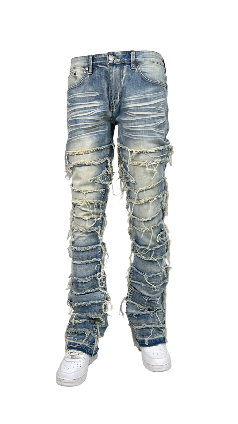 Men’s distressed stacked jeans in light blue wash with heavy shredded detailing and layered denim texture