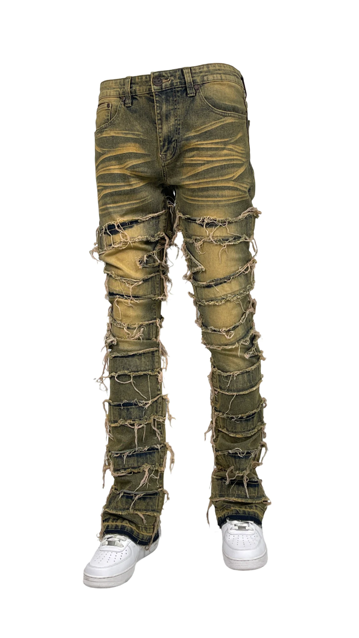 Men’s olive green distressed stacked jeans with heavy ripped and frayed detailing and faded wash texture.