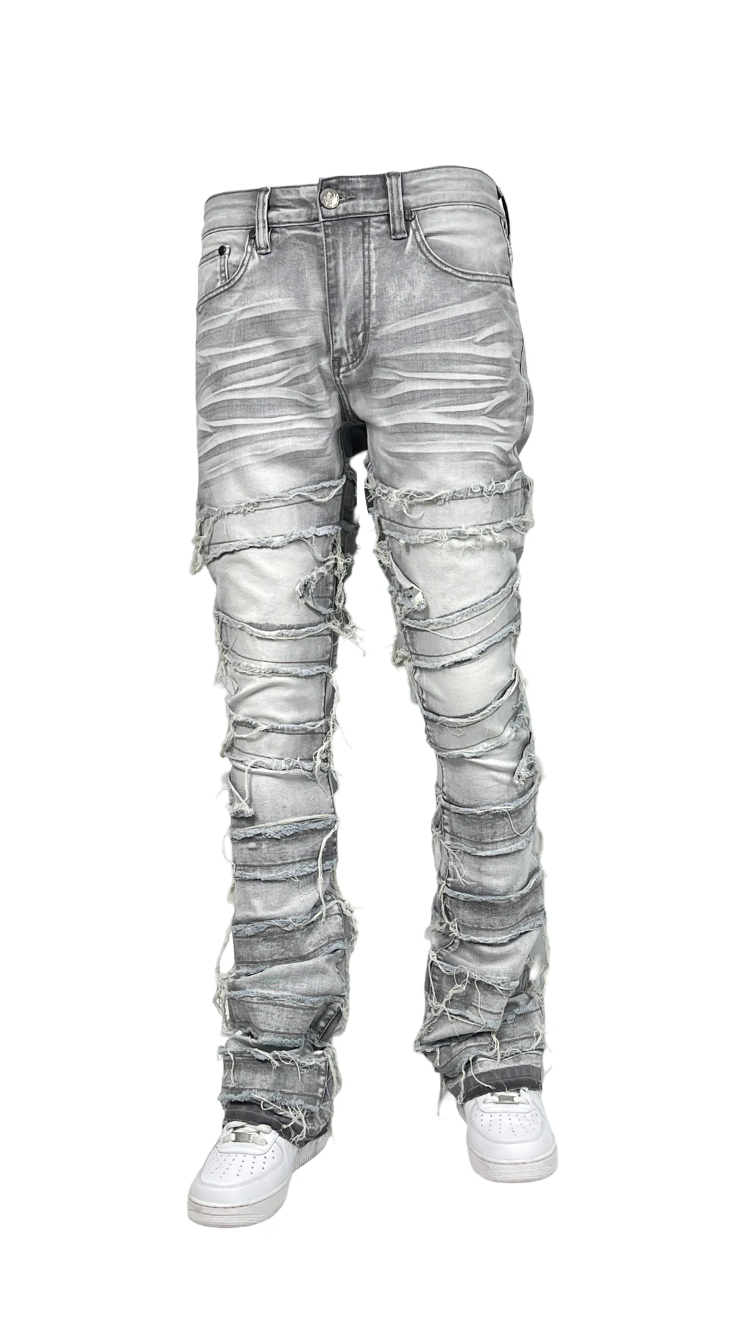 Men’s distressed stacked jeans in grey wash with heavy shredded detailing and layered denim texture