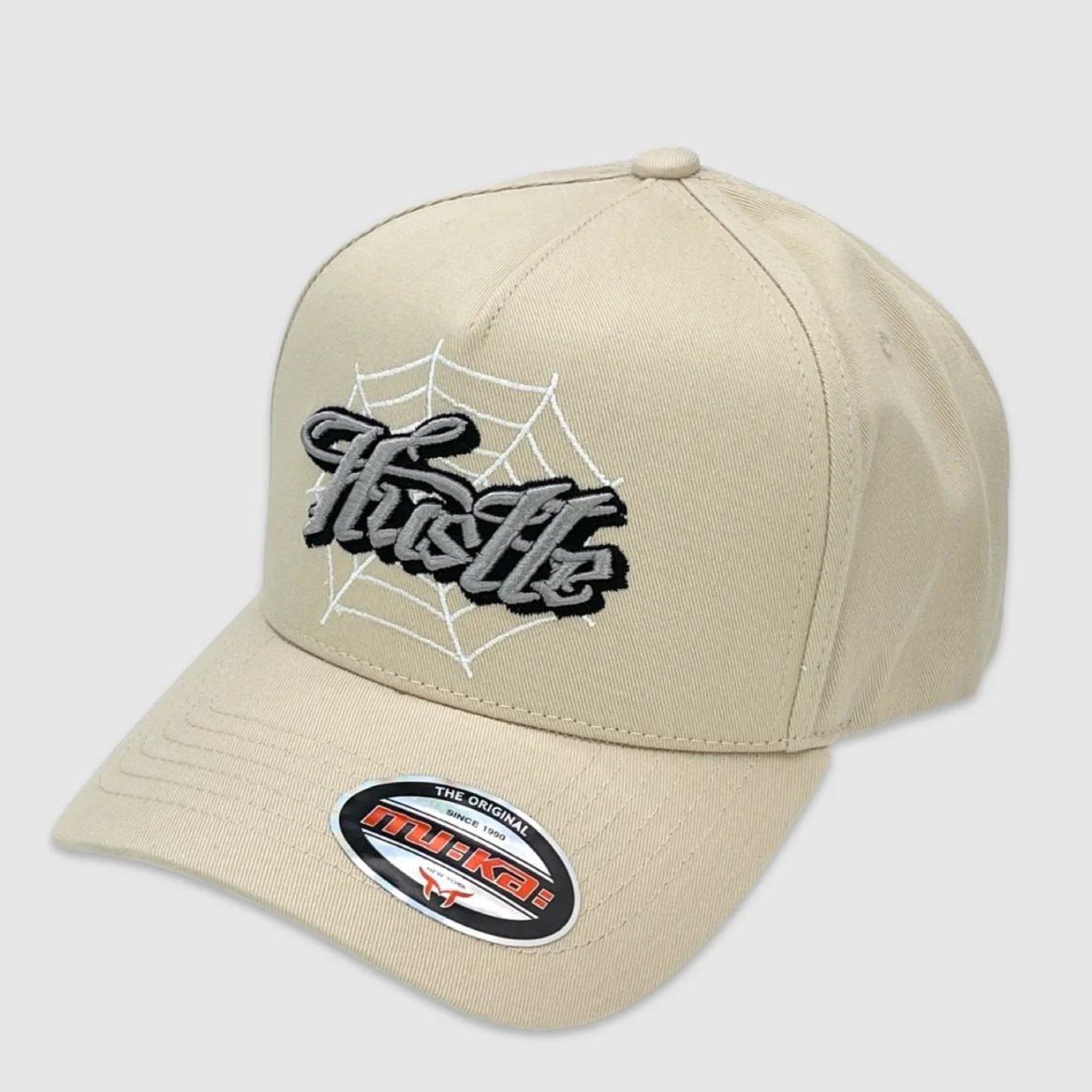 Beige snapback hat with embroidered Hustle text and spiderweb design