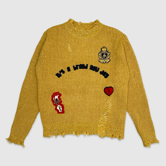 Front view of mustard distressed knit sweater with embroidered patches including 'It's a Brand New Day', crest, torch, and broken heart – urban streetwear by City Grid Apparel